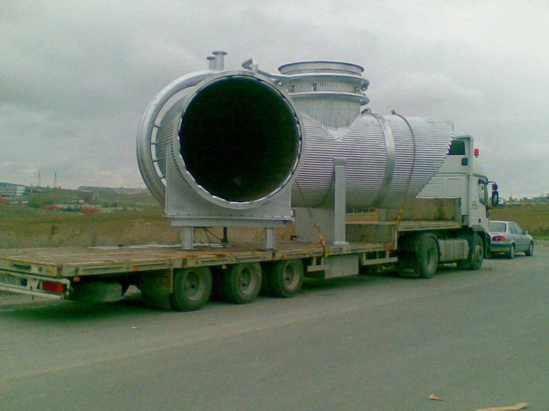 Large cylindrical industrial equipment loaded on a flatbed trailer
